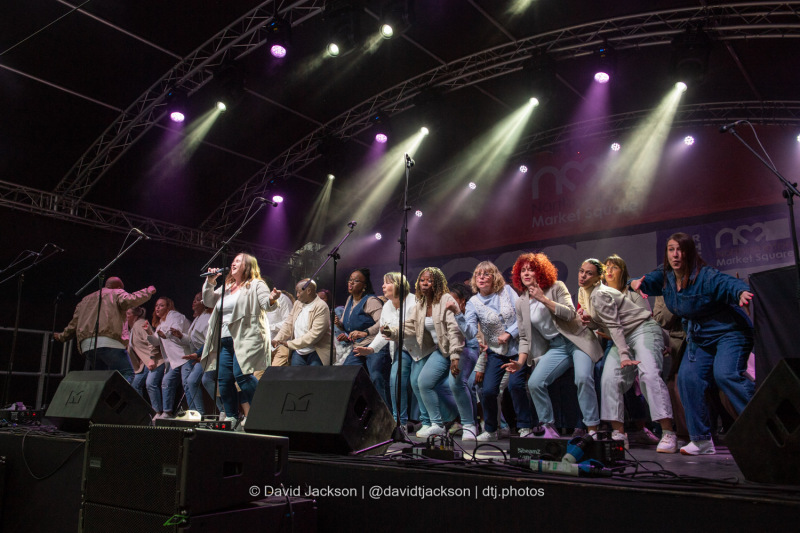 The Northants Sings Out Choir on stage at the Market Square in Northampton on Sunday, October 20, 2024, performing as part of a weekend of activities celebrating its official reopening. Photo by David Jackson.